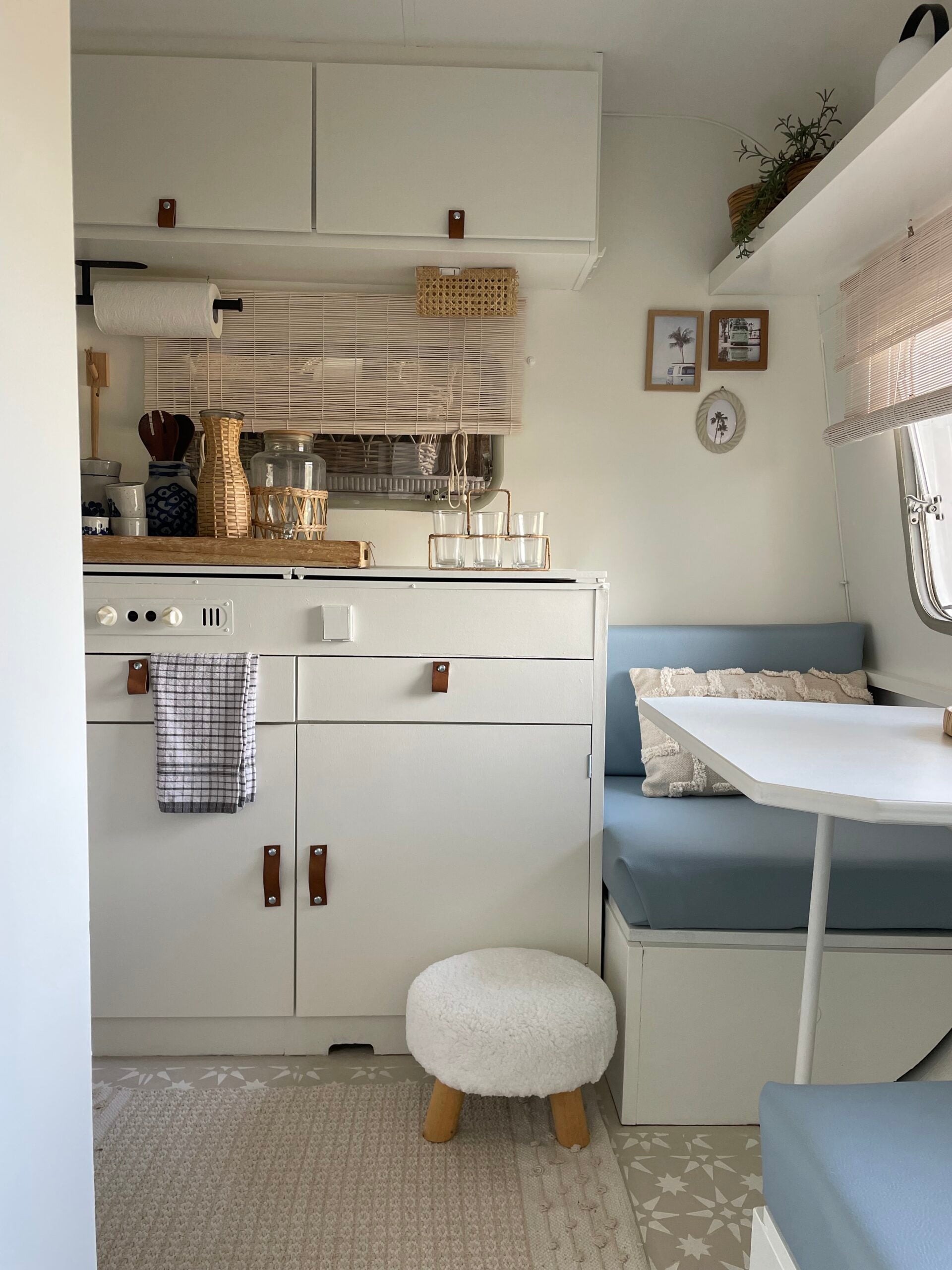 Stylish interior of the Adria 305 caravan, featuring a cozy seating area, modern kitchen, and light color palette.