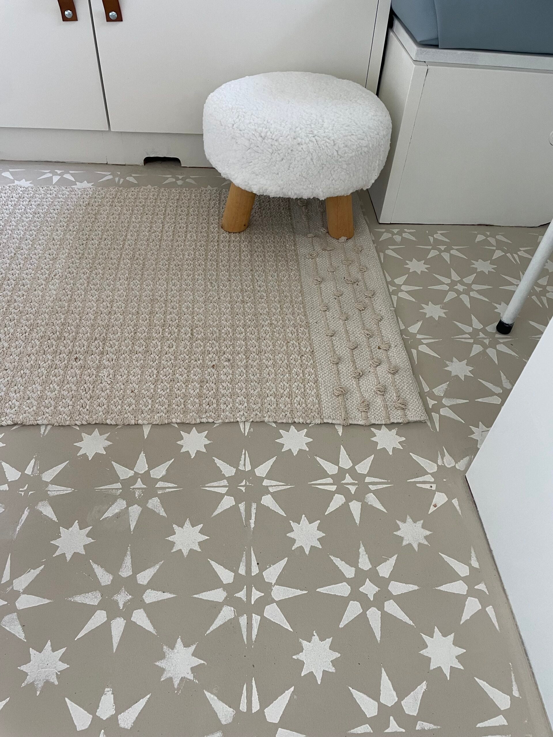 Cozy interior featuring a textured rug beside a fluffy stool on a patterned floor with star motifs.
